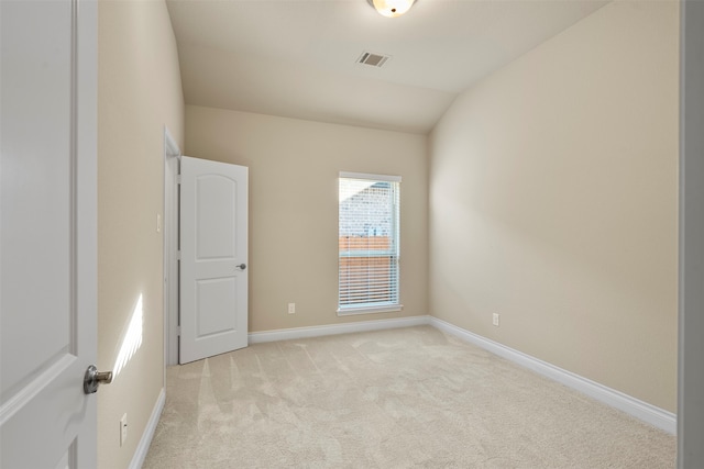 carpeted empty room featuring vaulted ceiling