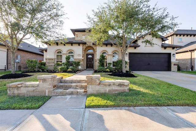 mediterranean / spanish-style house featuring a garage, stone siding, concrete driveway, and stucco siding