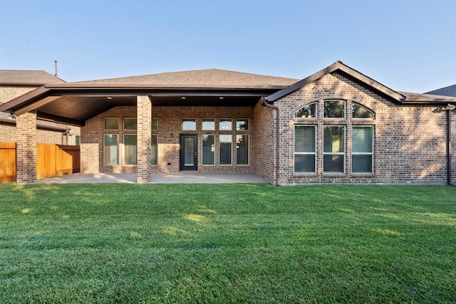 back of house with a patio area and a yard