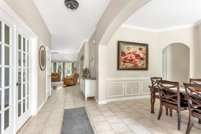 hall with light tile patterned flooring, crown molding, and french doors