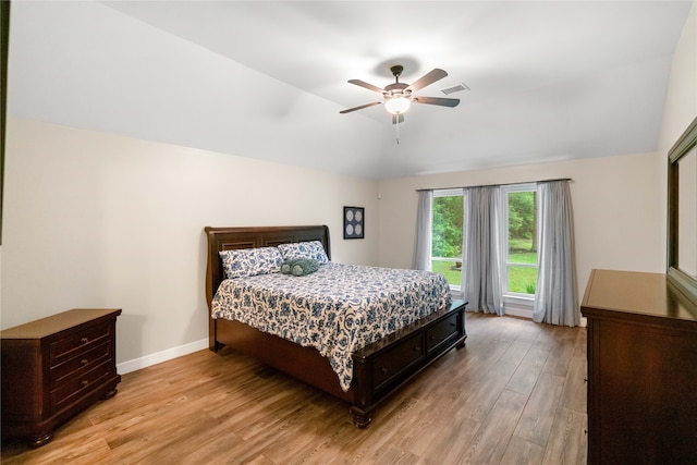 bedroom with ceiling fan, light wood-type flooring, and vaulted ceiling