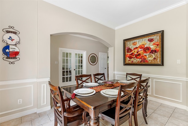 dining room featuring light tile patterned floors, ornamental molding, and french doors