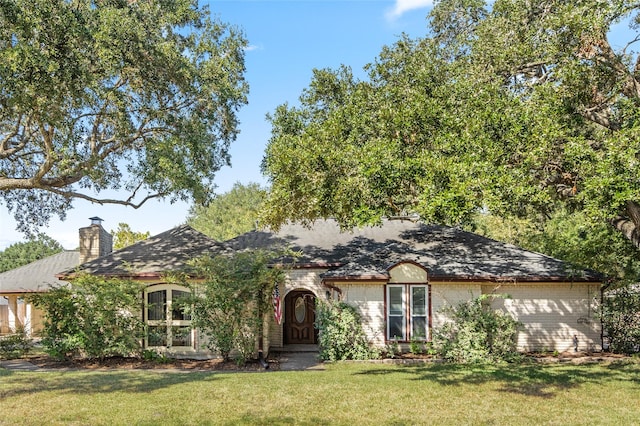 view of front of property with a chimney and a front lawn