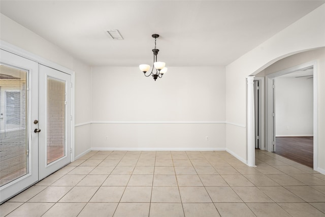 1133 Sally Anne Dr, Rosenberg, TX 77471 - unfurnished room with light tile patterned floors, arched walkways, a chandelier, and baseboards