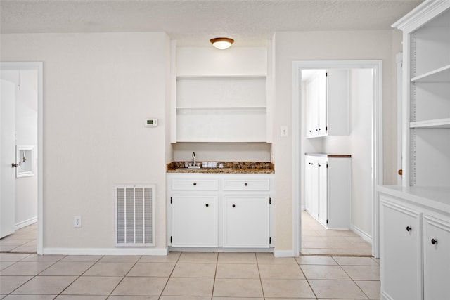 1133 Sally Anne Dr, Rosenberg, TX 77471 - kitchen featuring open shelves, light tile patterned floors, white cabinets, and baseboards