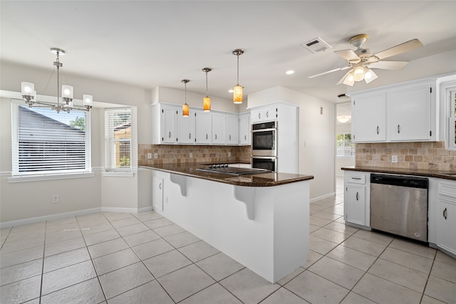 kitchen with white cabinets, stainless steel appliances, kitchen peninsula, and decorative backsplash