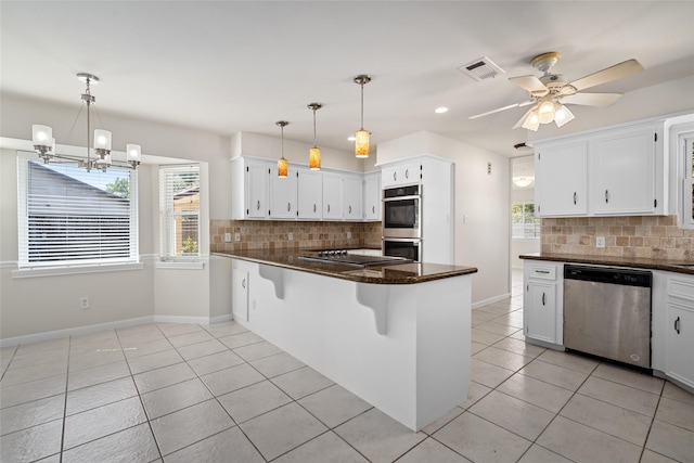 1133 Sally Anne Dr, Rosenberg, TX 77471 - kitchen with appliances with stainless steel finishes, a peninsula, light tile patterned floors, tasteful backsplash, and dark stone countertops