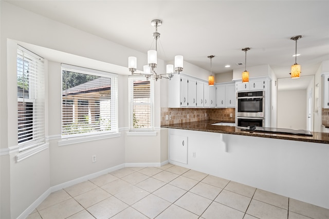 kitchen featuring kitchen peninsula, decorative light fixtures, white cabinetry, stainless steel appliances, and decorative backsplash