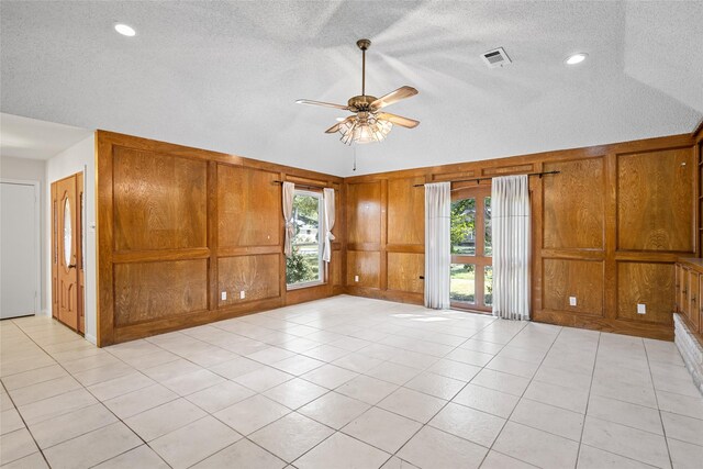 1133 Sally Anne Dr, Rosenberg, TX 77471 - unfurnished room with a textured ceiling, a ceiling fan, lofted ceiling, light tile patterned flooring, and wooden walls