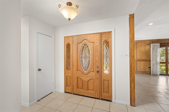 foyer featuring baseboards and light tile patterned floors