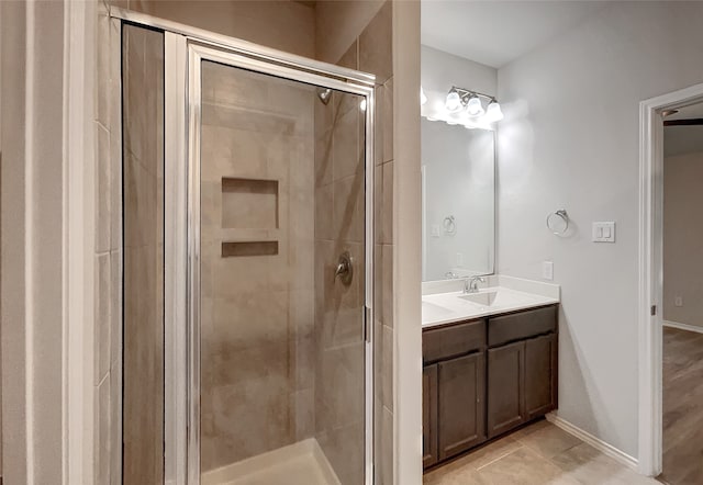 bathroom featuring tile patterned floors, a shower with door, and vanity