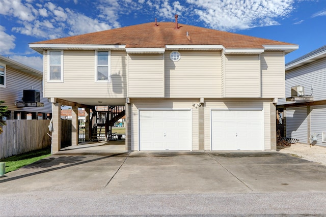 back of house featuring a garage and central AC