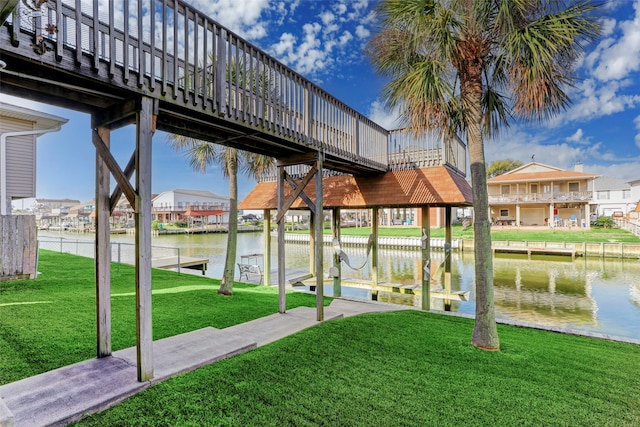 view of dock with a water view and a lawn