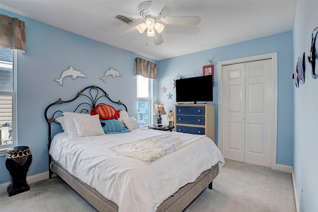 bedroom featuring a closet, light carpet, and ceiling fan