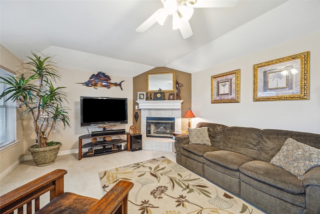 carpeted living room featuring lofted ceiling, a tile fireplace, and ceiling fan