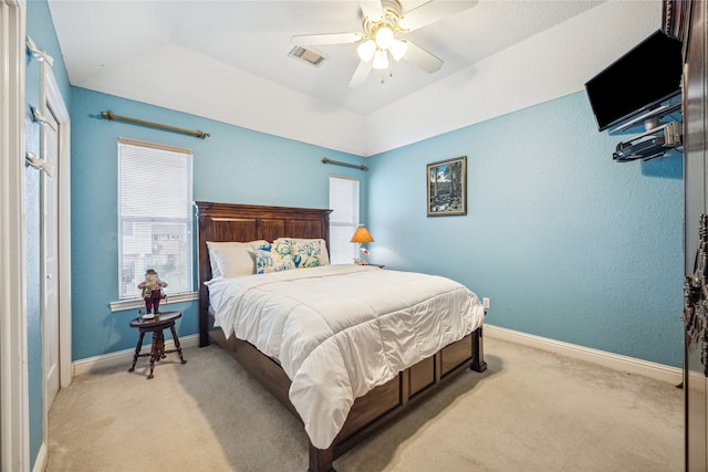 bedroom featuring ceiling fan, multiple windows, and light colored carpet