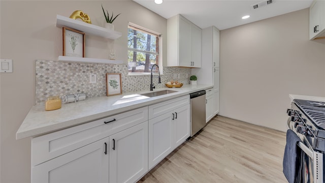 kitchen featuring white cabinets, stainless steel appliances, light wood-type flooring, and sink