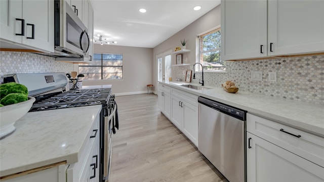 kitchen featuring appliances with stainless steel finishes, plenty of natural light, sink, and light hardwood / wood-style floors