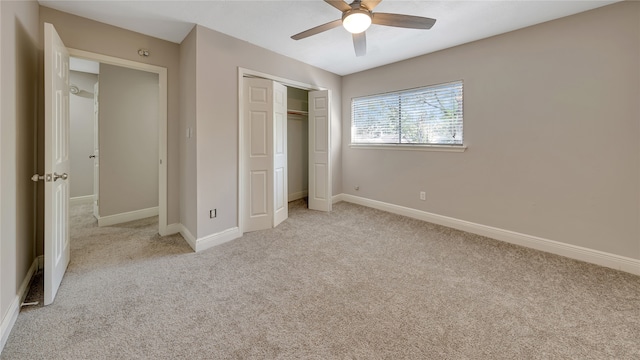 unfurnished bedroom featuring ceiling fan, a closet, and light carpet