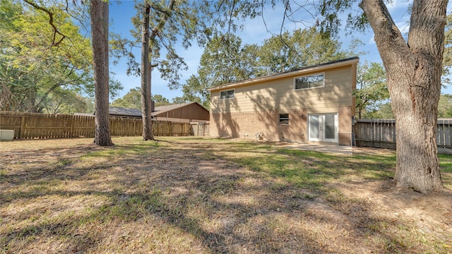 back of property with a yard and a patio area