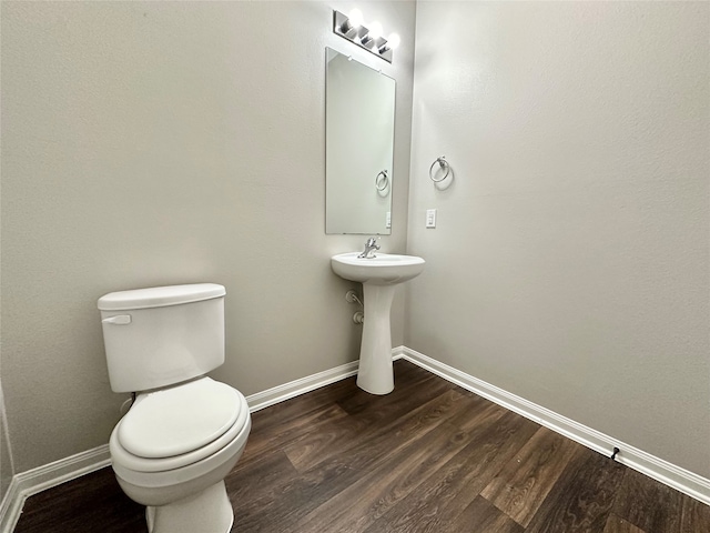 bathroom with hardwood / wood-style floors, sink, and toilet