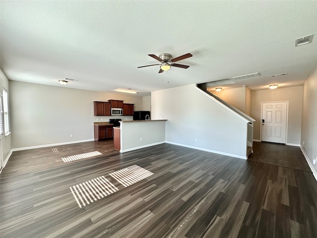 unfurnished living room with ceiling fan, a textured ceiling, and dark hardwood / wood-style floors