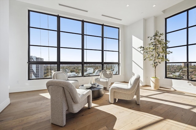 living area featuring recessed lighting, baseboards, a towering ceiling, and hardwood / wood-style floors