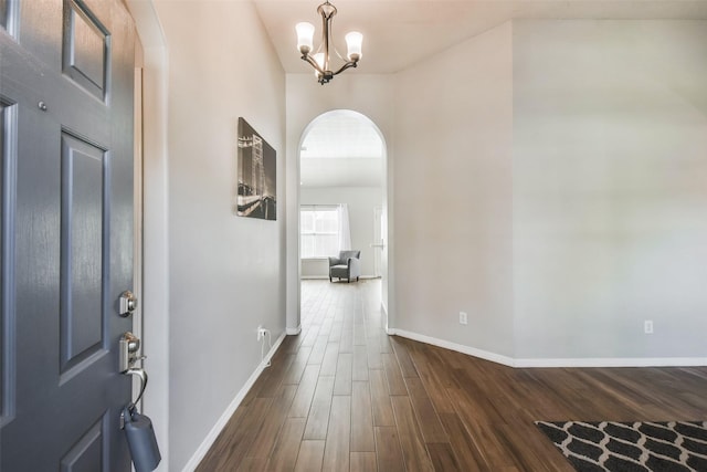 foyer entrance with dark wood-type flooring and a chandelier