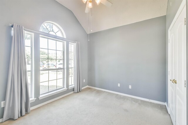 unfurnished room with ceiling fan, vaulted ceiling, and light carpet