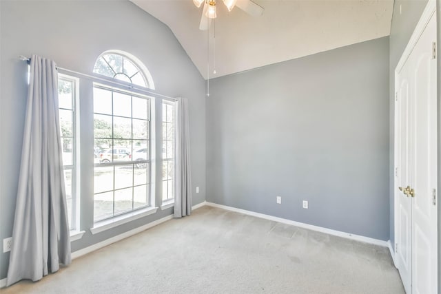 unfurnished room with ceiling fan, light colored carpet, and lofted ceiling