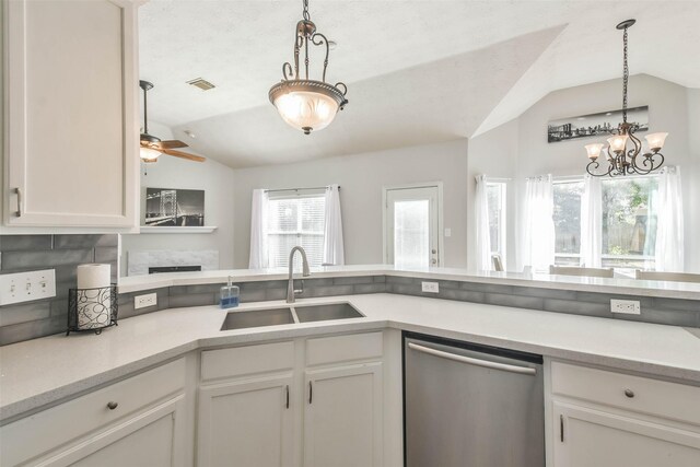 kitchen featuring lofted ceiling, sink, decorative light fixtures, white cabinetry, and dishwasher