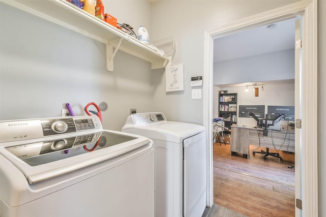 washroom with washing machine and dryer and light hardwood / wood-style floors