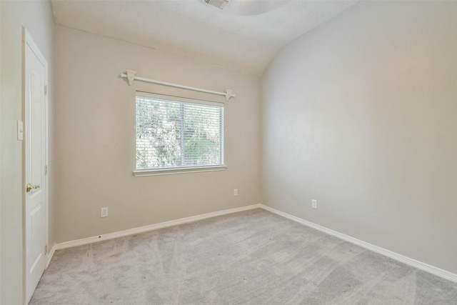 unfurnished room featuring light colored carpet and vaulted ceiling