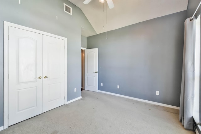 unfurnished bedroom featuring high vaulted ceiling, light colored carpet, a closet, and ceiling fan