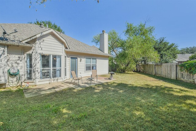 back of property with a yard and a patio