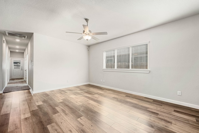 spare room featuring wood-type flooring, a textured ceiling, and ceiling fan