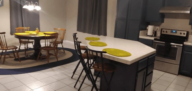 kitchen with light tile patterned flooring, ventilation hood, a center island, and stainless steel electric range