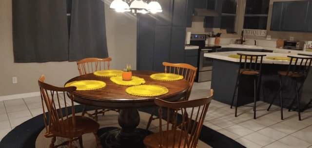 tiled dining space with a notable chandelier and sink