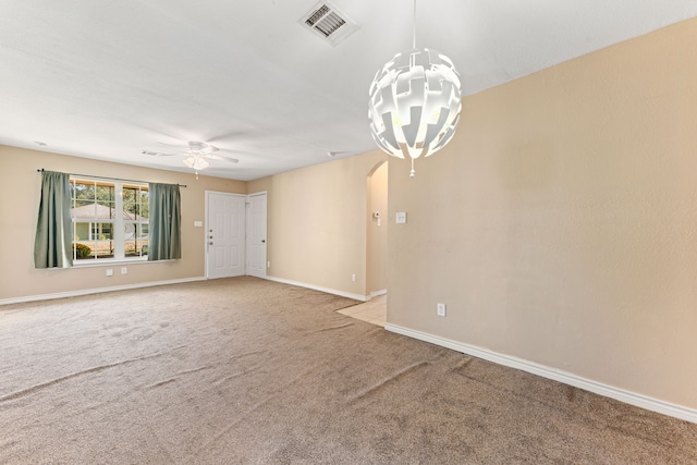 unfurnished room featuring ceiling fan with notable chandelier and carpet floors