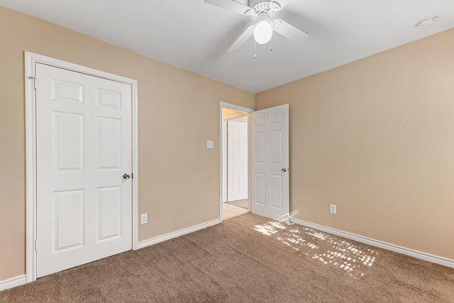 unfurnished bedroom featuring ceiling fan and light carpet