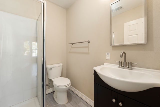 bathroom featuring vanity, toilet, and an enclosed shower