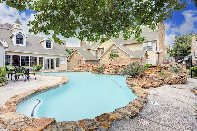 pool featuring a patio, fence, and french doors