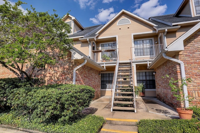 view of front of home with a balcony and a patio area