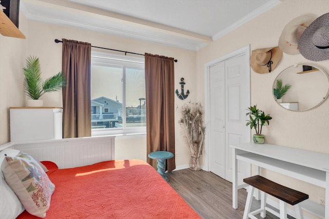 bedroom featuring wood-type flooring, a closet, and ornamental molding