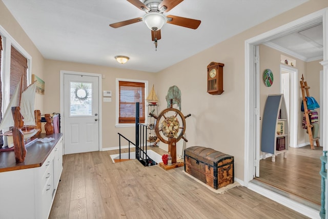 entryway with ornamental molding, light wood-type flooring, and ceiling fan