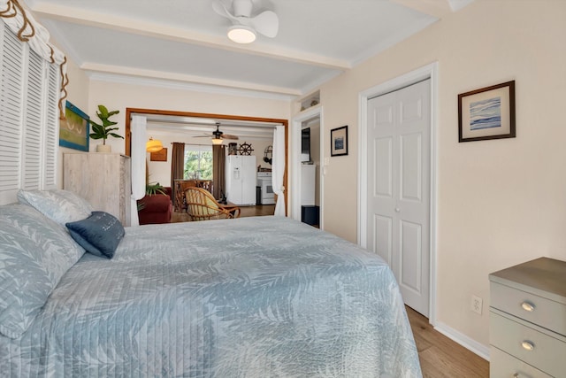 bedroom featuring white fridge with ice dispenser and light wood-type flooring