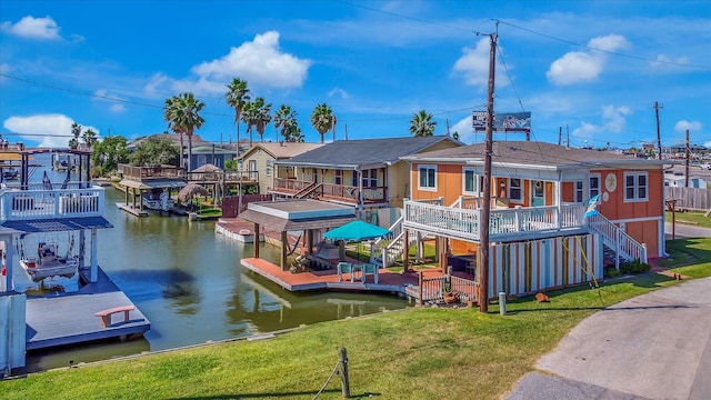 rear view of house featuring a lawn and a deck with water view