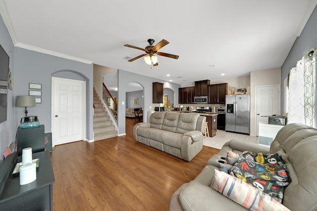 living room with ceiling fan, light wood-type flooring, and ornamental molding