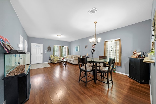 dining space with an inviting chandelier and dark hardwood / wood-style floors