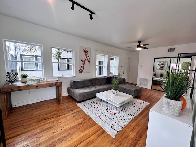 living room with track lighting, hardwood / wood-style flooring, and ceiling fan